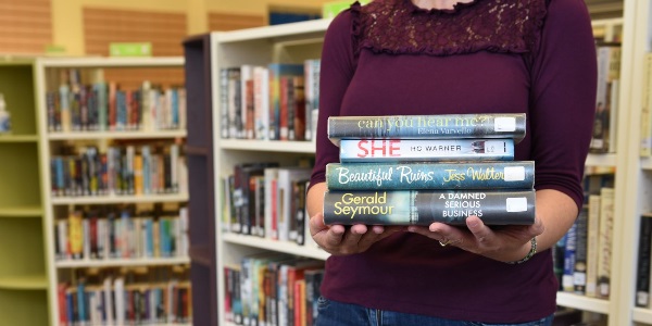 A person holding a bundle of books