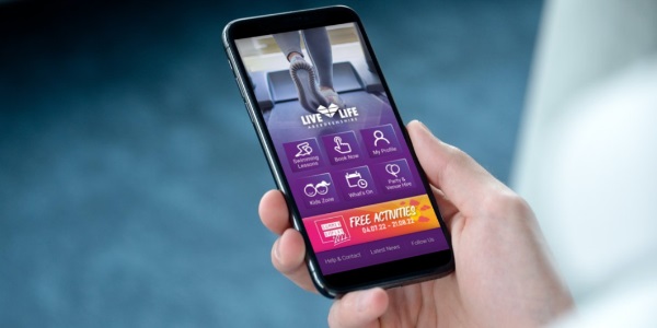 A person holding a phone showing the LLA app
